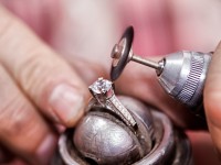 Ein Designer für angewandte Formgebung, Schmuck und Gerät repariert den Diamantring einer Kundin.