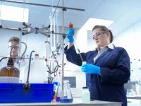 Eine Chemielaborjungwerkerin testet Chemikalien in einer Galvanikfabrik.