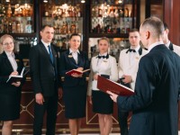 Ein Assistent für Hotelmanagement macht ein Teambriefing, bevor das Bankett beginnt.