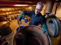 Ein Destillateur stellt Gin nach traditionellen und handwerklichen Methoden mit Wacholderbeeren her.