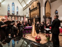 Ein Kirchenmusiker leitet den Chor in einer Kirche an.
