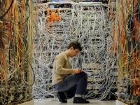 Ein Elektroniker überprüft Kabel für verschiedene Telekommunikationsnetze.