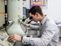 Ein physikalisch-technischer Assistent misst eine Probe am Elektronenmikroskop.