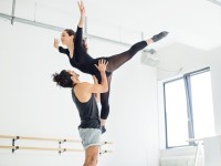 Eine Bühnentänzerin und ein Bühnentänzer proben ein Ballettstück ein.