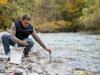 Ein umweltschutztechnischer Assistent untersucht die Wasserqualität eines Fließgewässers.