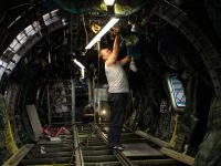 Ein Fluggerätelektroniker installiert neue elektrische Leitungen in einem Flugzeug.