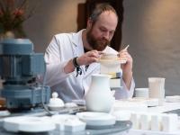 Ein Industriekeramiker arbeitet in der Besucherwerkstatt der Porzellan-Manufaktur Fürstenberg an einem Korb aus Porzellan.