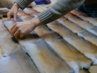 Ein Kürschner legt die Anordnung der Felle fest.