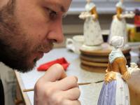 Ein Manufakturporzellanmaler bemalt die Kleidung der Porzellanfigur "Schokoladenmädchen" in der Staatlichen Porzellan-Manufaktur Meissen.