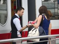 Ein Schaffner berät eine Frau vor einem Zug.