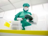 Eine Mikrotechnologin arbeitet mit Wafern im Reinraum am Fraunhofer-Institut für Mikroelektronische Schaltungen und Systeme.