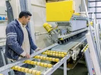 Ein Naturwerksteinmechaniker bearbeitet Marmor mit einer Maschine.