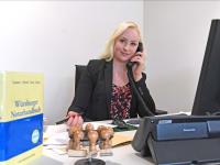 Eine Notarfachangestellte kümmert sich um die telefonische Korrespondenz mit einem Mandanten.