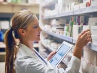 Eine Pharmazeutisch-kaufmännische Angestellte prüft den Medikamentenbestand in der Apotheke.