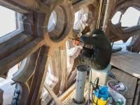 Eine Steinmetzin restauriert eine Strebe im Westturm vom Münster in Freiburg.