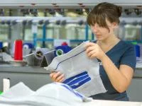 Eine Textil- und Modenäherin prüft die Qualität einer Kniebandage. 