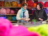 Zwei Textilgestalterinnen arbeiten in der Filzmanufaktur Retzow an farbigen Filzprodukten.