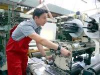 Ein Kunststoff- und Kautschuktechnologe bedient eine Maschine zum Zuschneiden von Kunststofffolie.