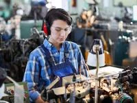 Eine Werkgehilfin Schmuckwarenindustrie, Taschen- und Armbanduhren verarbeitet Ersatzteile für eine Armbanduhr an einer Maschine.