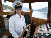 Eine Binnenschifffahrtskapitänin steuert die Fähre über den Tegernsee.